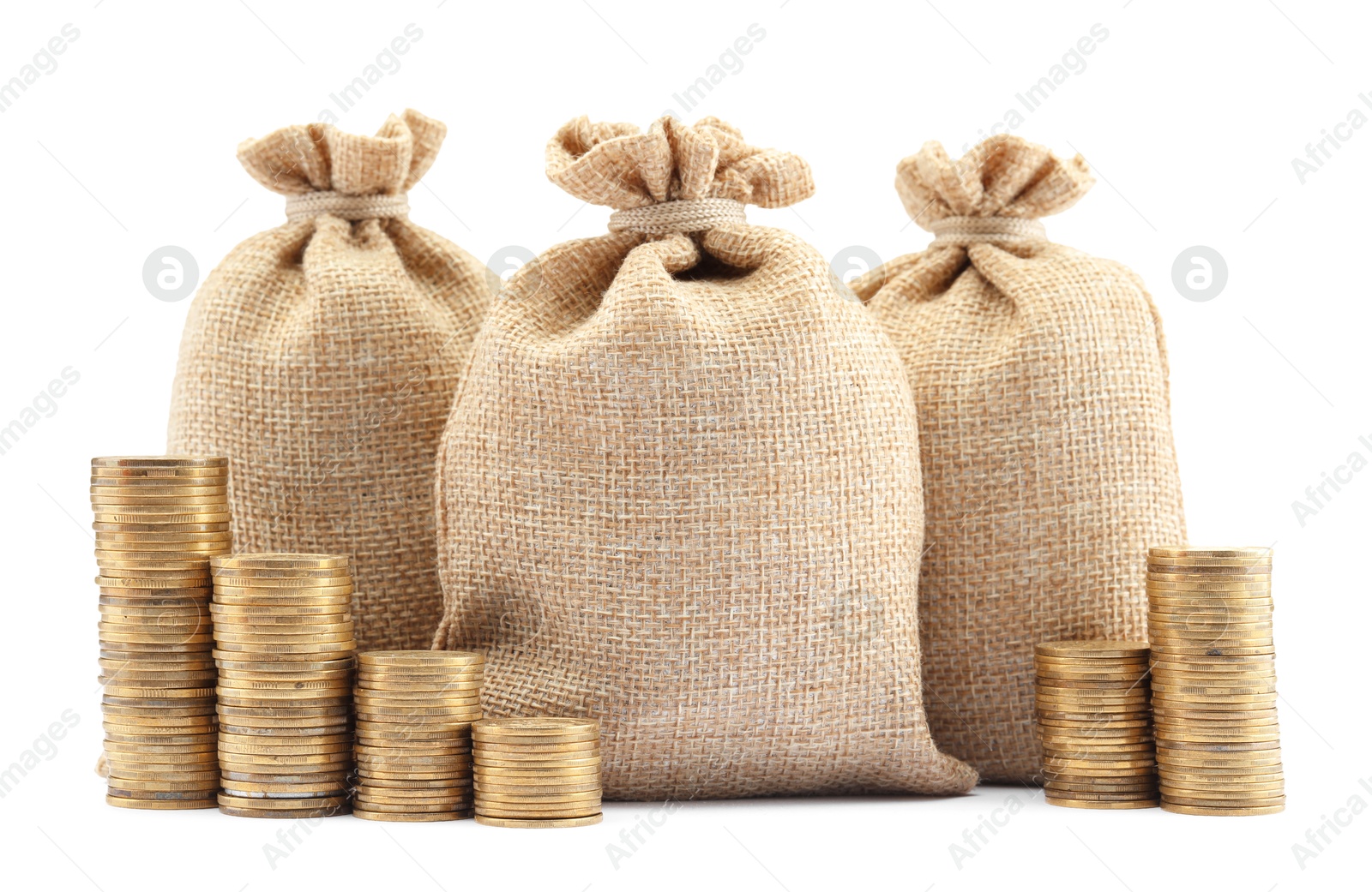 Bags and stacked coins isolated on white Photo of Bags and stacked coins isolated on white