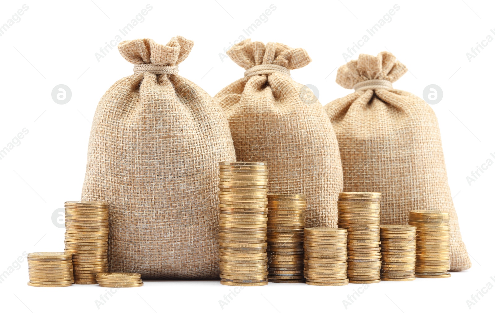 Bags and stacked coins isolated on white Photo of Bags and stacked coins isolated on white