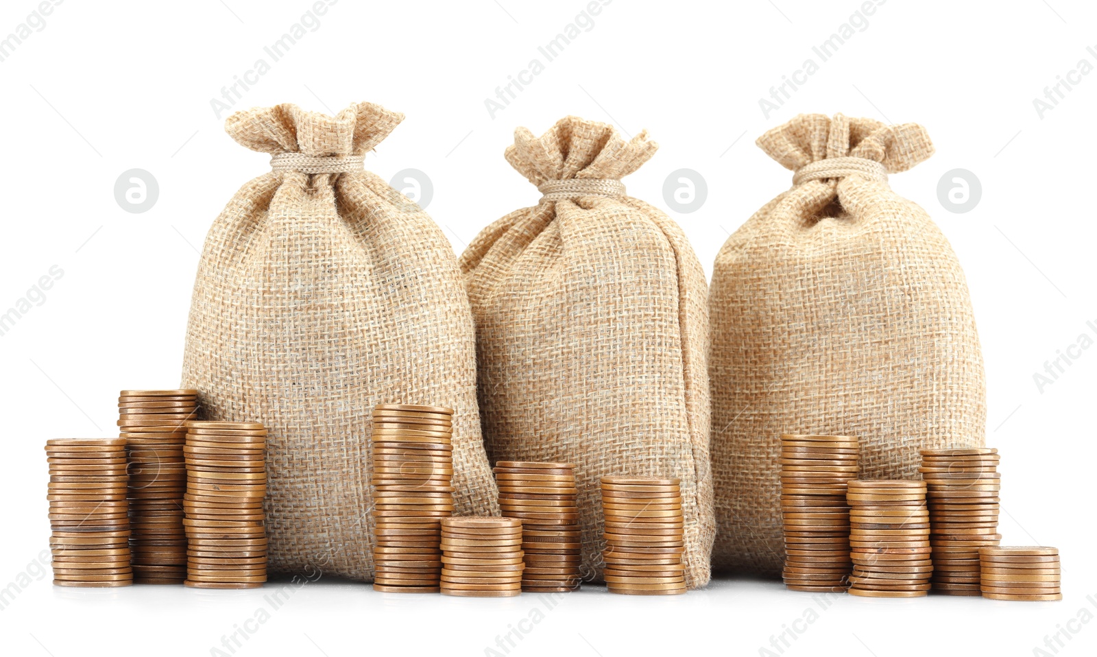 Bags and stacked coins isolated on white Photo of Bags and stacked coins isolated on white