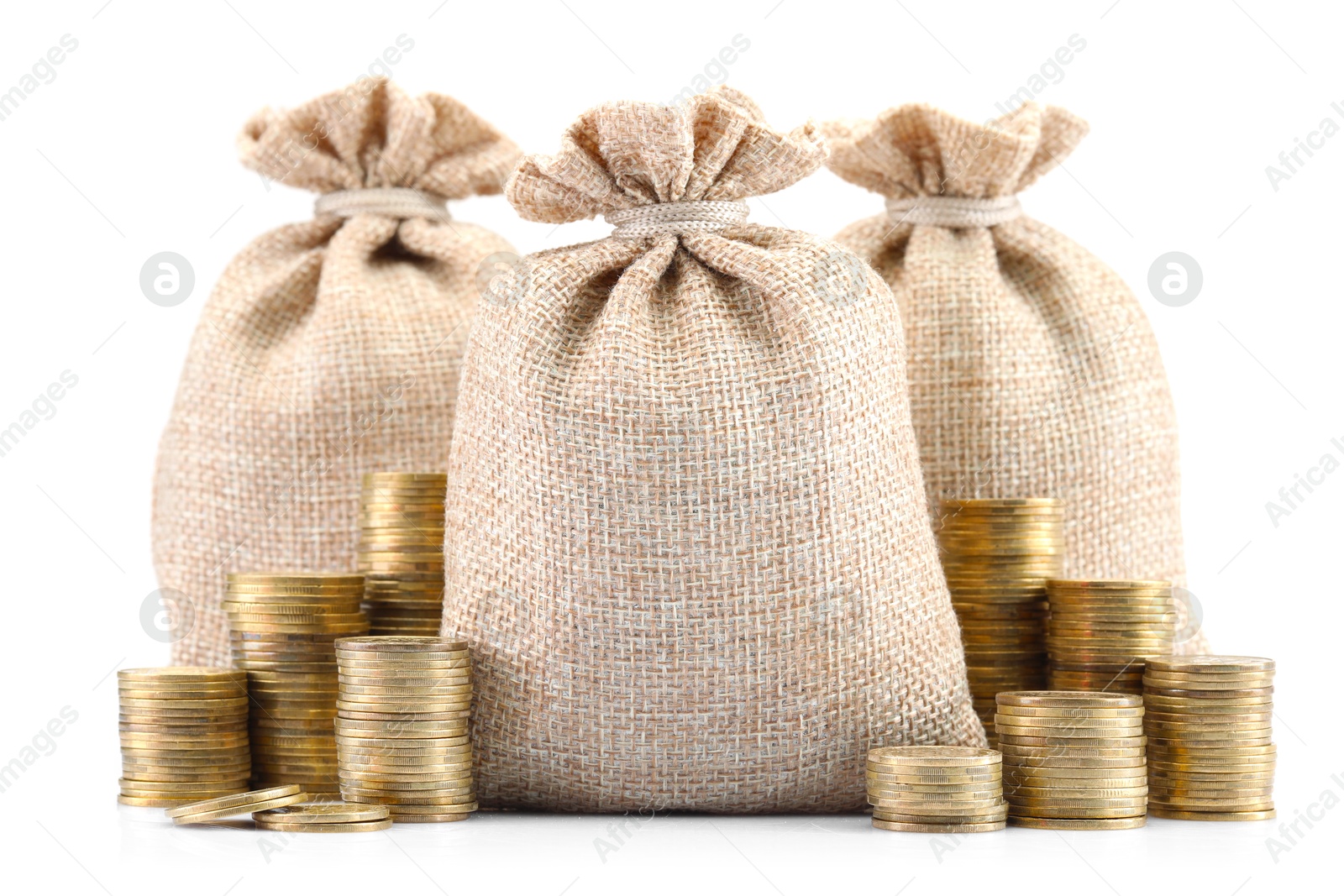 Bags and stacked coins isolated on white Photo of Bags and stacked coins isolated on white
