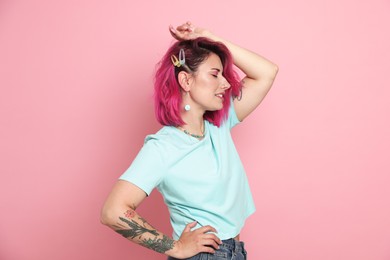 Photo of Beautiful woman with bright dyed hair on pink background