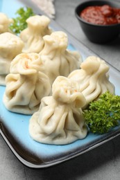 Photo of Delicious khinkali served on grey table, closeup