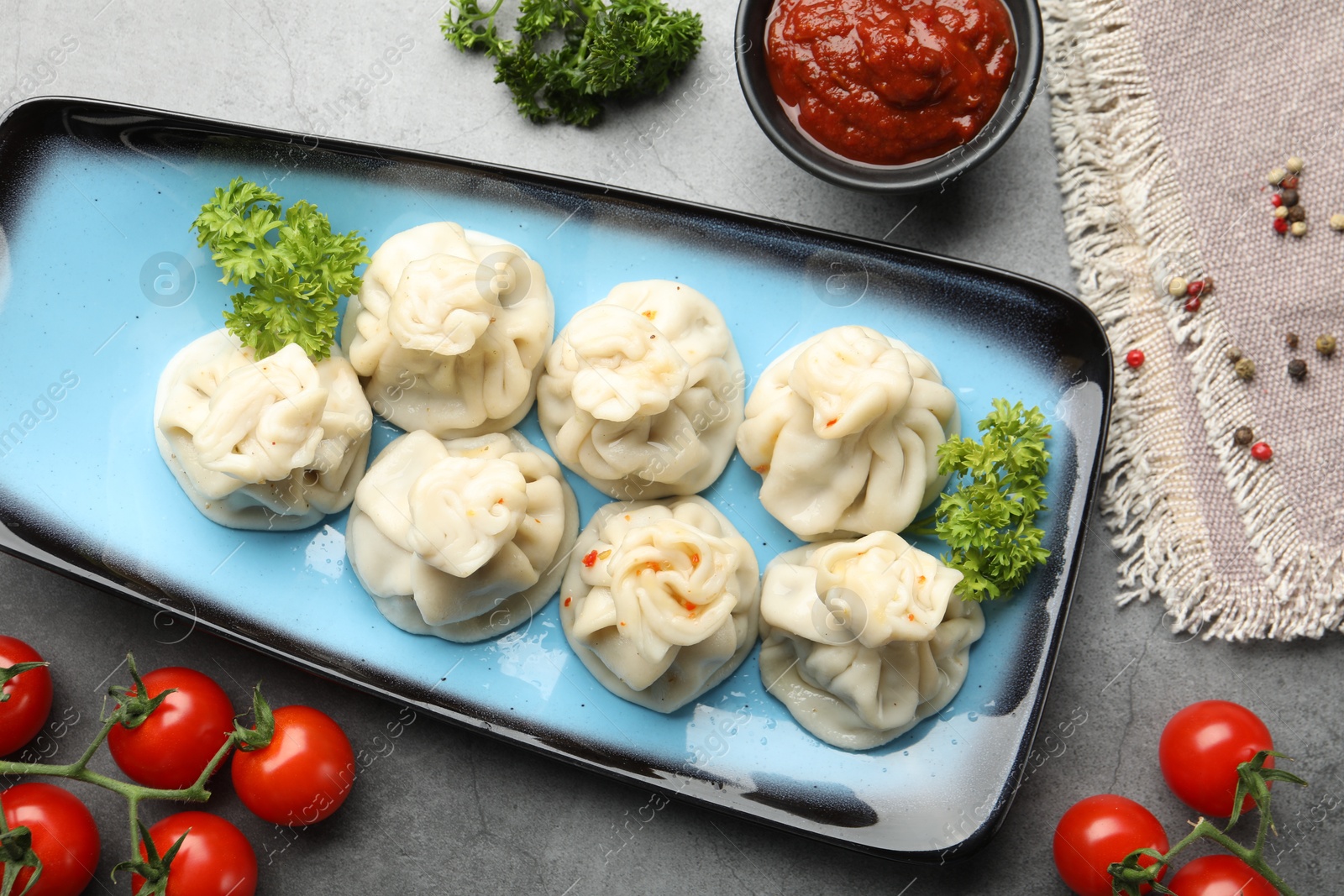 Delicious khinkali served on grey table, flat lay Photo of Delicious khinkali served on grey table, flat lay
