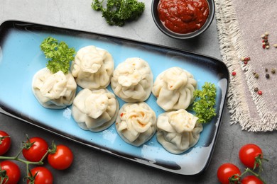 Photo of Delicious khinkali served on grey table, flat lay