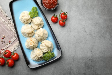 Photo of Delicious khinkali served on grey table, flat lay. Space for text