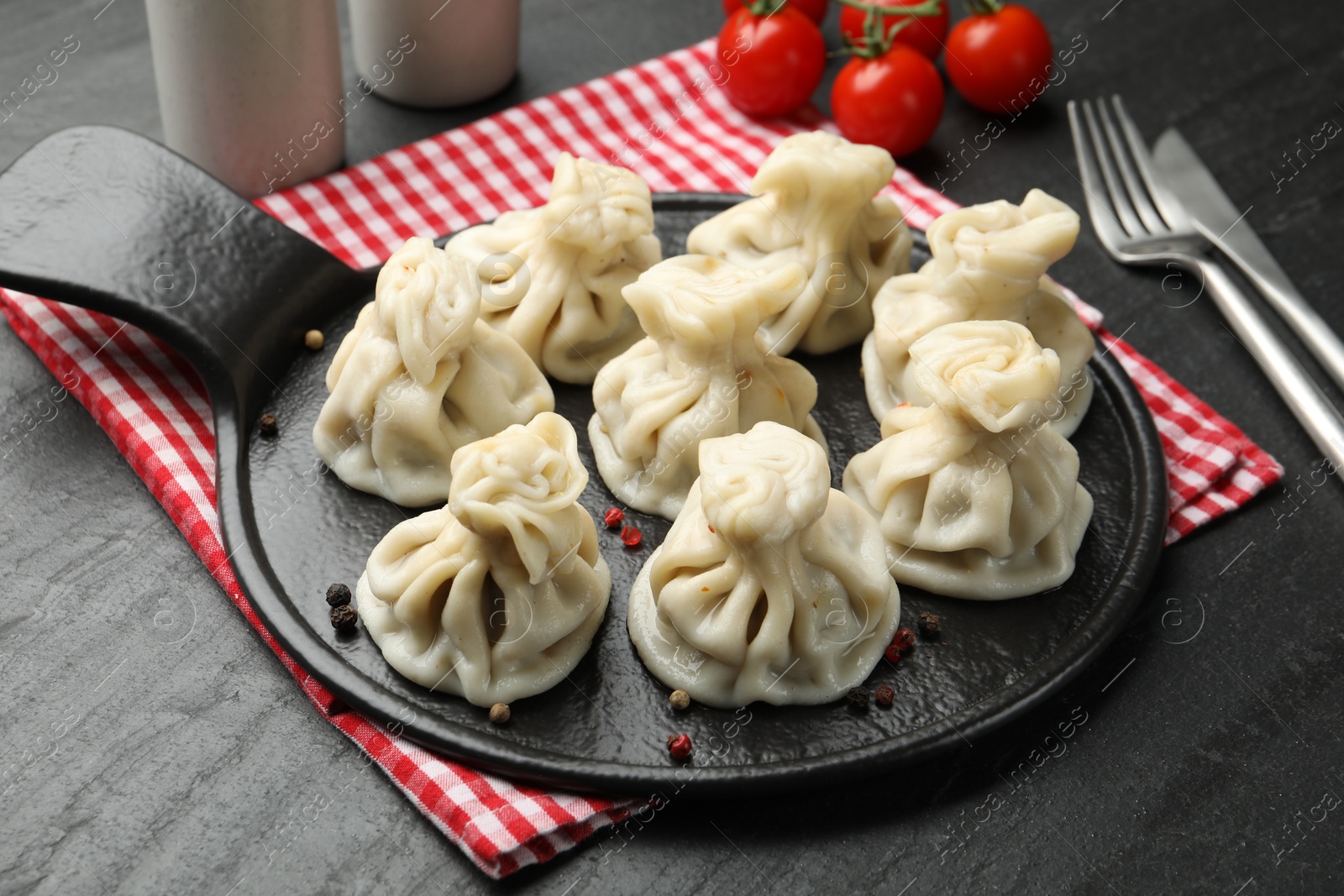 Photo of Delicious khinkali served on black table, closeup