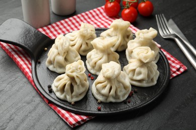 Photo of Delicious khinkali served on black table, closeup