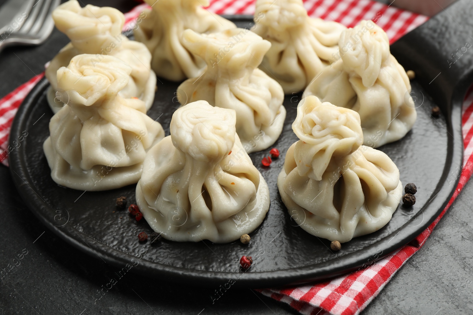Delicious khinkali with spices on black table, closeup Photo of Delicious khinkali with spices on black table, closeup