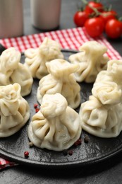 Photo of Delicious khinkali served on black table, closeup