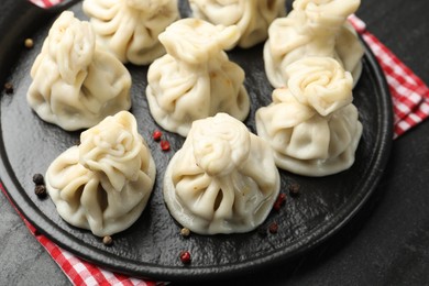 Photo of Delicious khinkali with spices on black table, above view