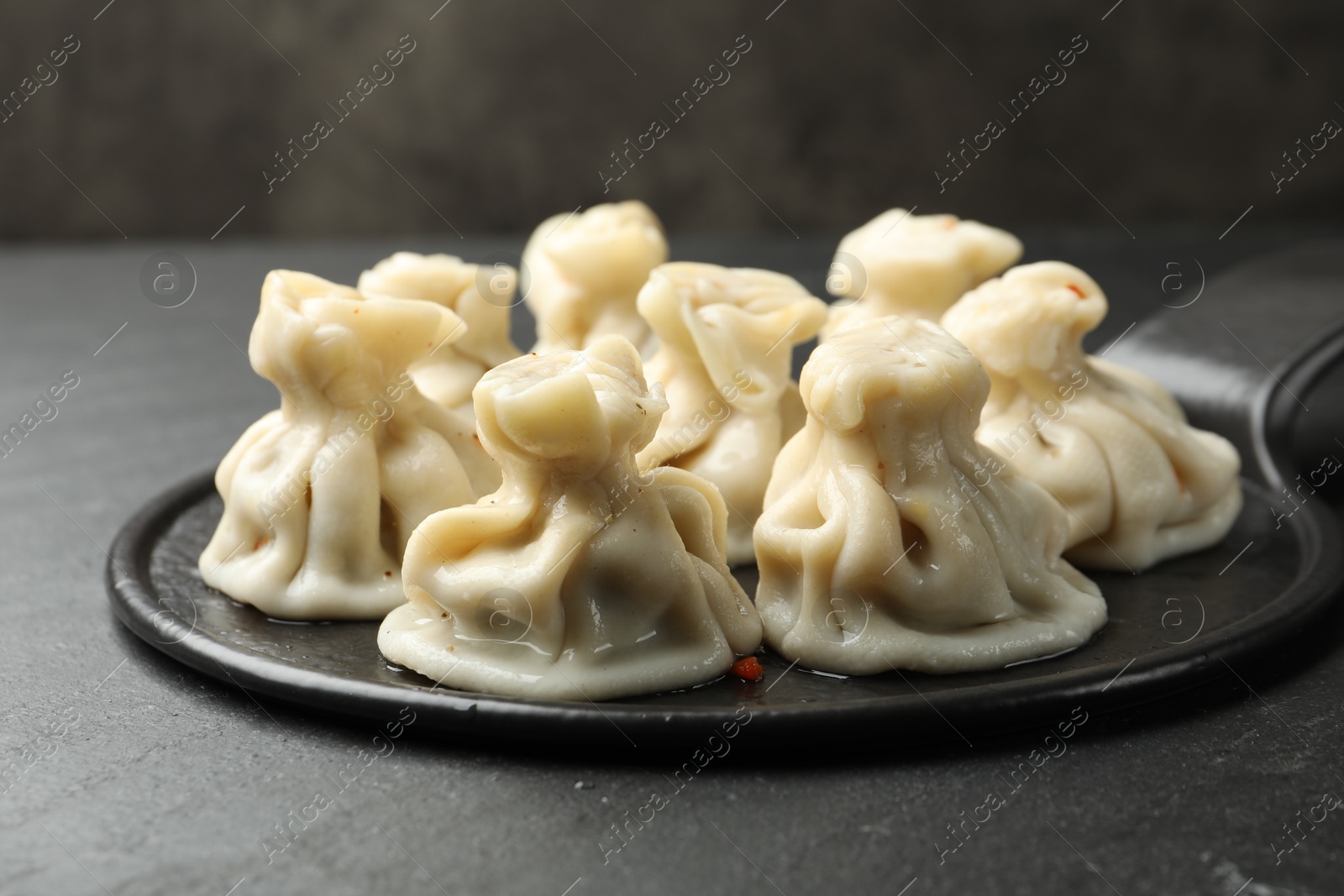 Delicious khinkali with spices on black table, closeup Photo of Delicious khinkali with spices on black table, closeup