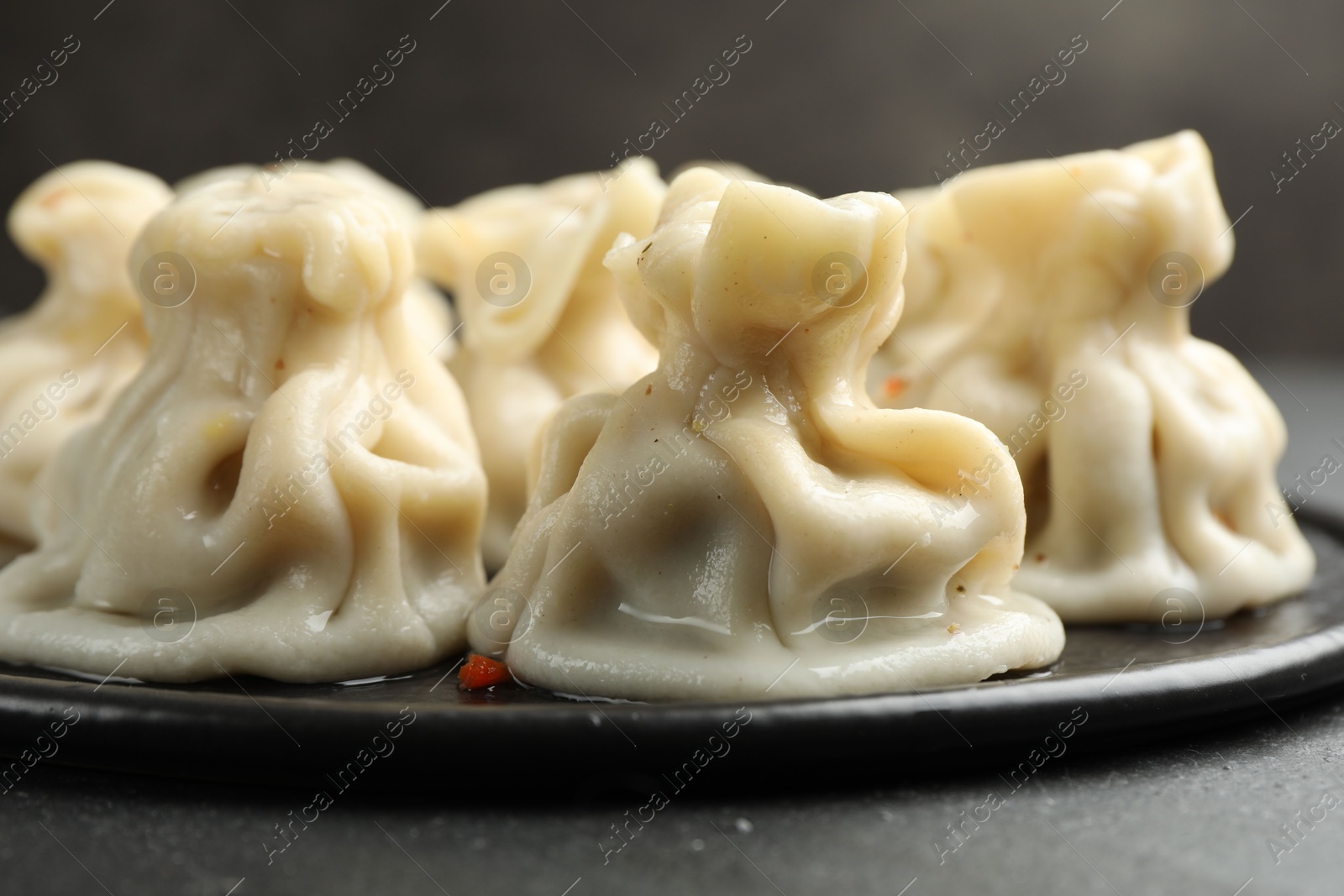 Delicious khinkali with spices on black table, closeup Photo of Delicious khinkali with spices on black table, closeup
