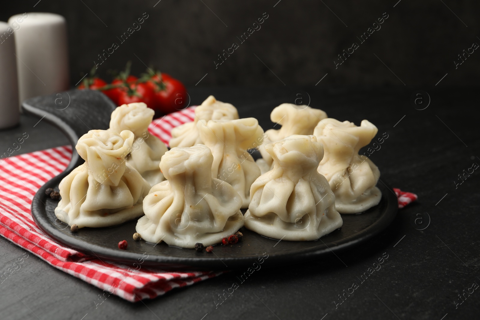Photo of Delicious khinkali served on black table, closeup