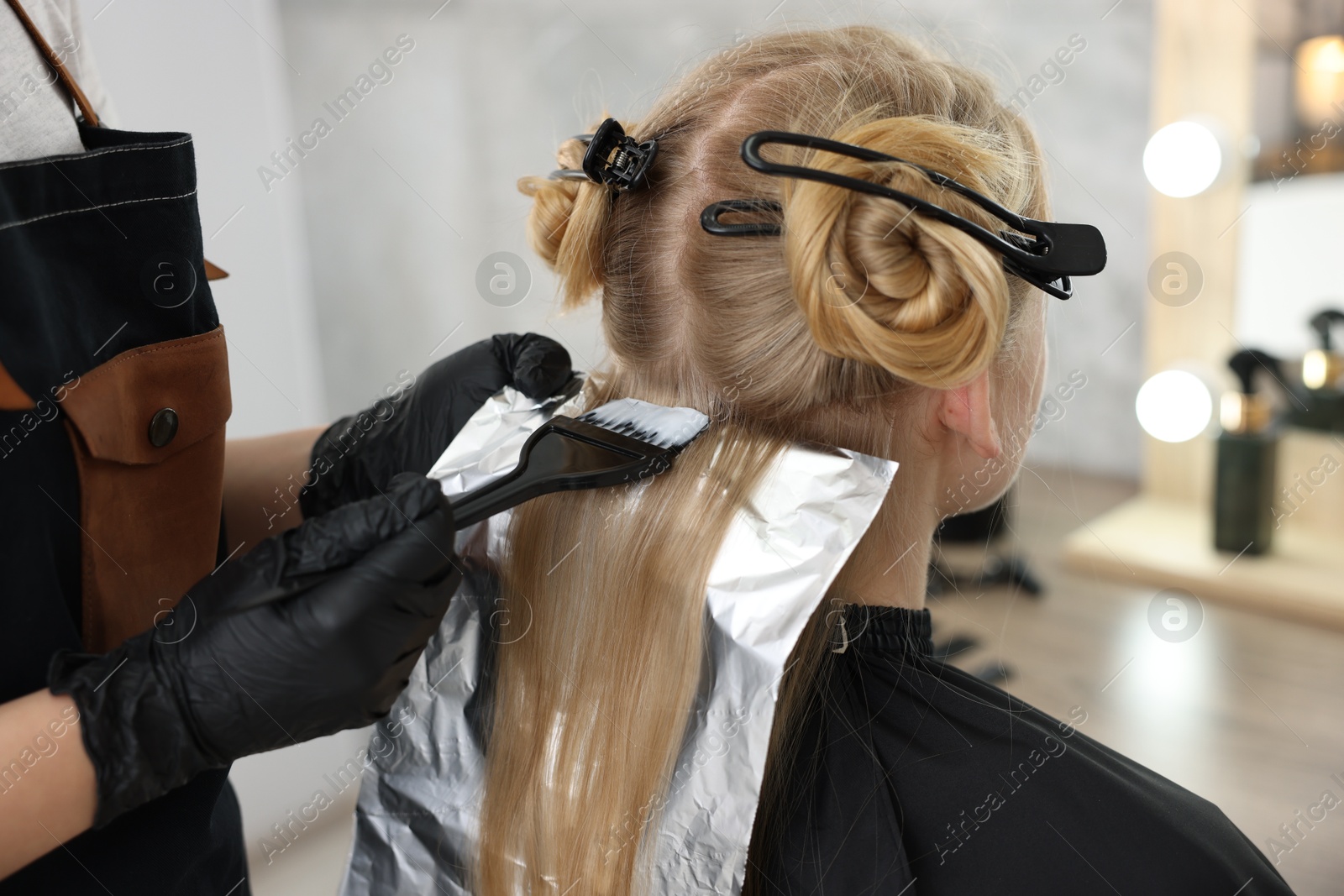 Hairdresser applying dye on woman's hair in salon, closeup Photo of Hairdresser applying dye on woman's hair in salon, closeup