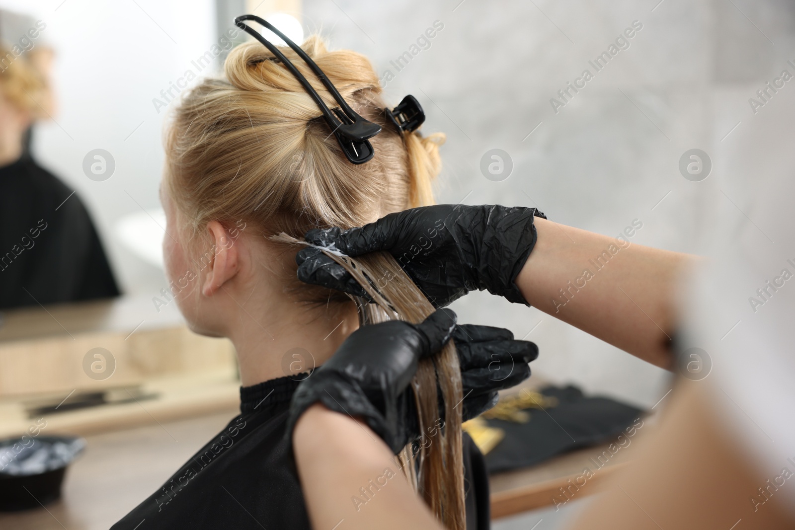 Hairdresser applying dye on woman's hair in salon, closeup Photo of Hairdresser applying dye on woman's hair in salon, closeup