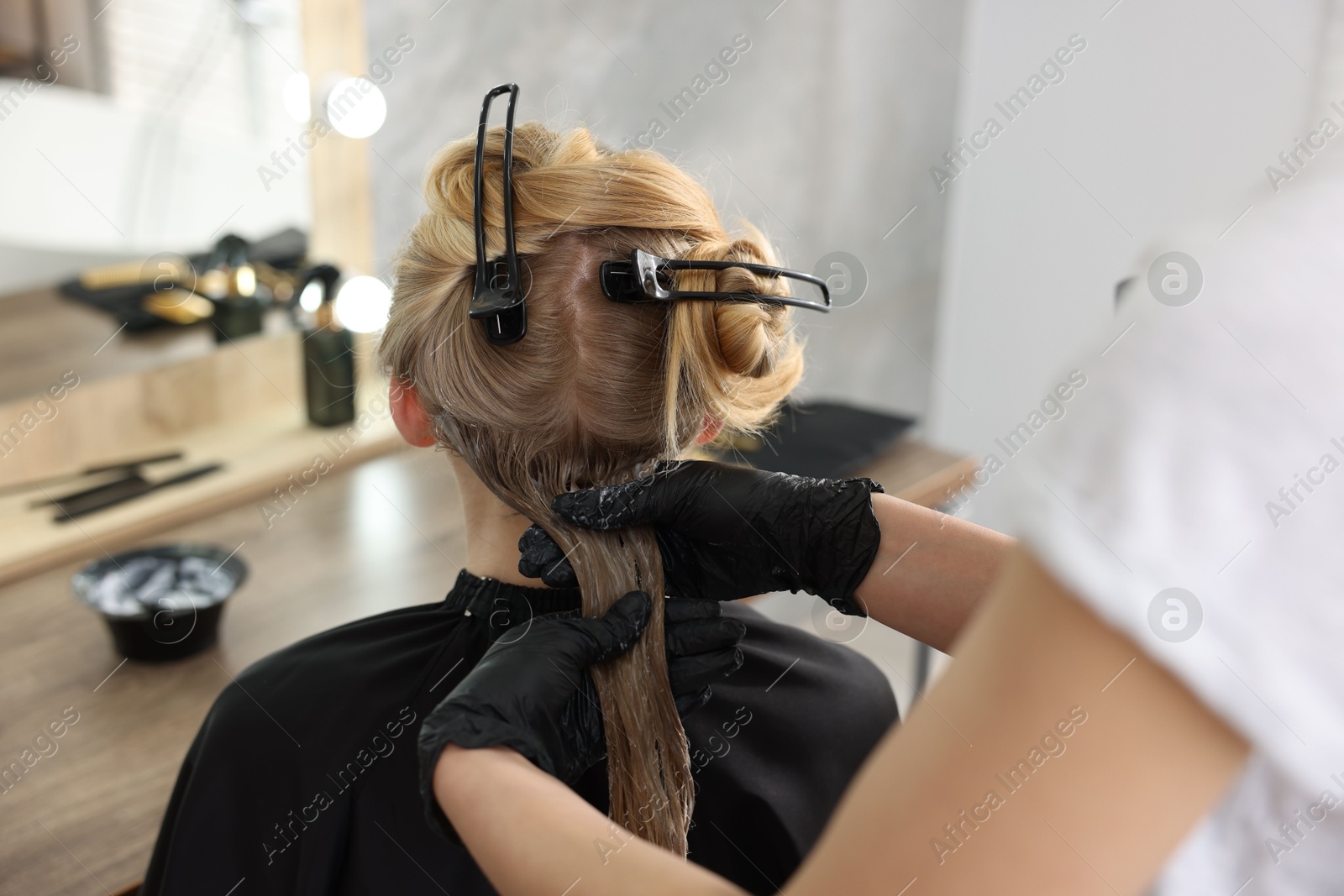 Hairdresser applying dye on woman's hair in salon, closeup Photo of Hairdresser applying dye on woman's hair in salon, closeup