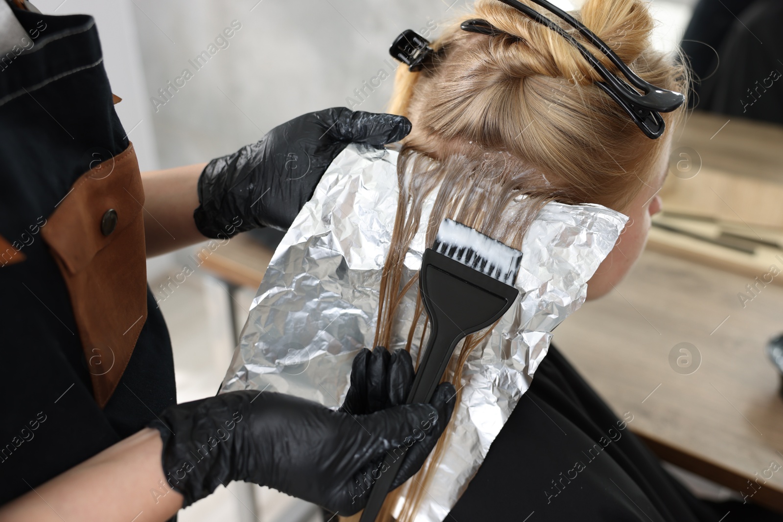 Hairdresser applying dye on woman's hair in salon, closeup Photo of Hairdresser applying dye on woman's hair in salon, closeup