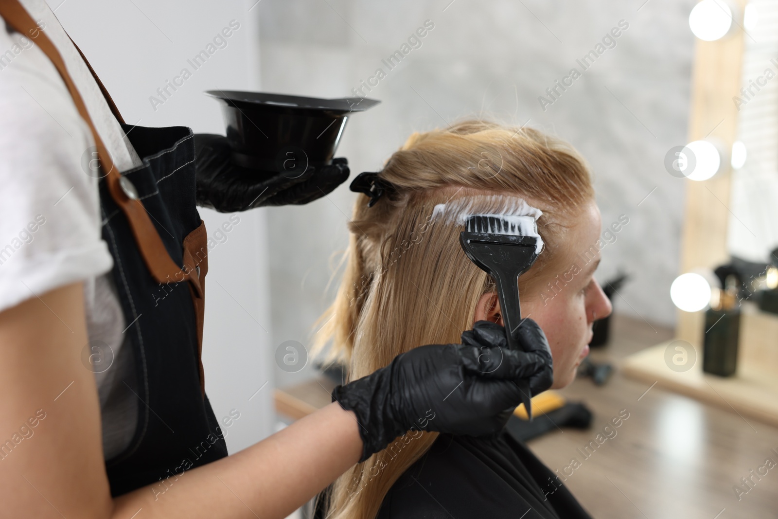 Hairdresser applying dye on woman's hair in salon, closeup Photo of Hairdresser applying dye on woman's hair in salon, closeup