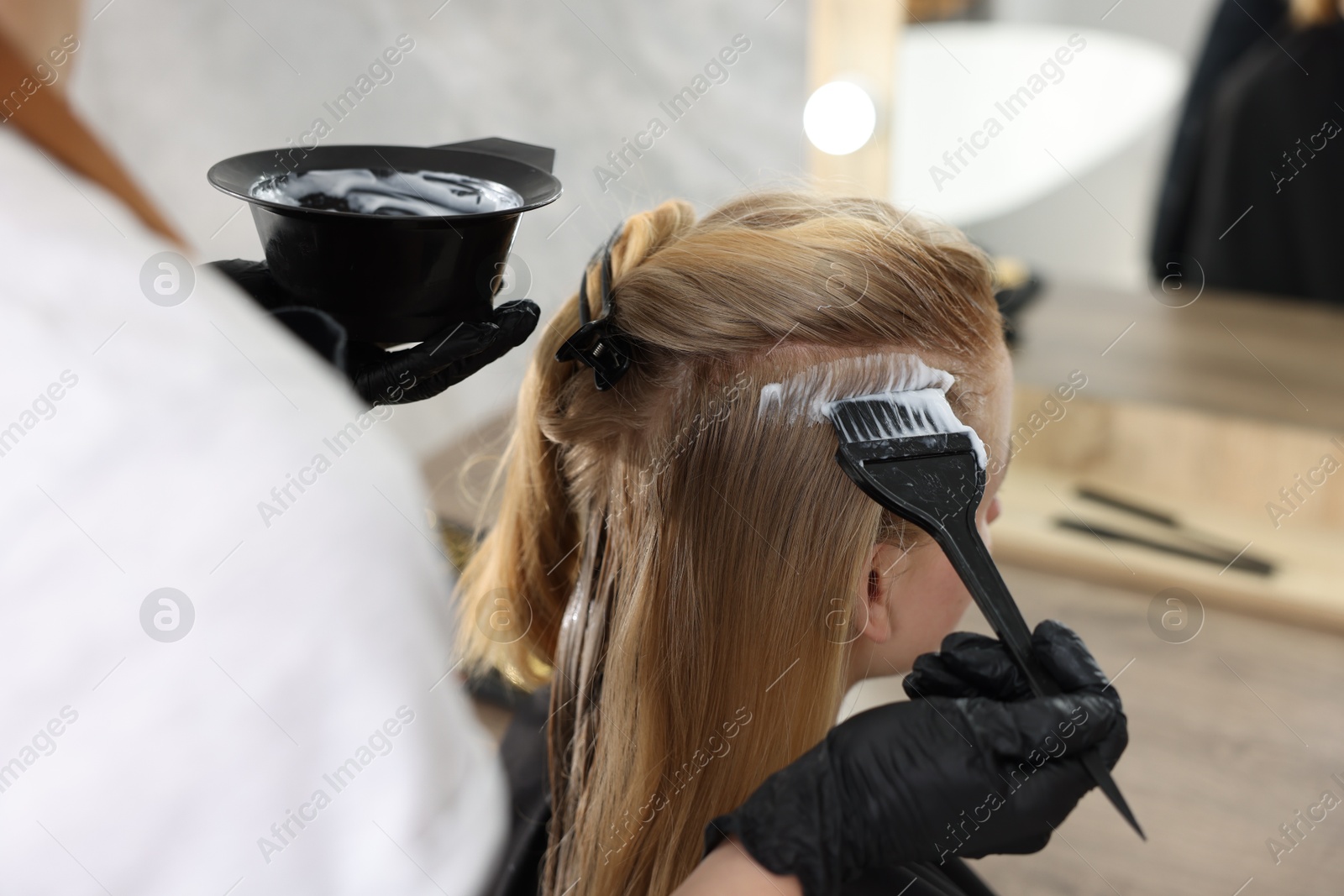 Hairdresser applying dye on woman's hair in salon, closeup Photo of Hairdresser applying dye on woman's hair in salon, closeup