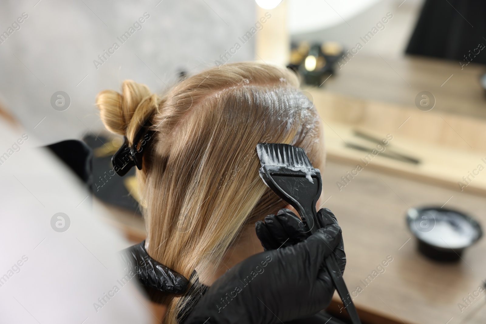 Hairdresser applying dye on woman's hair in salon, closeup Photo of Hairdresser applying dye on woman's hair in salon, closeup