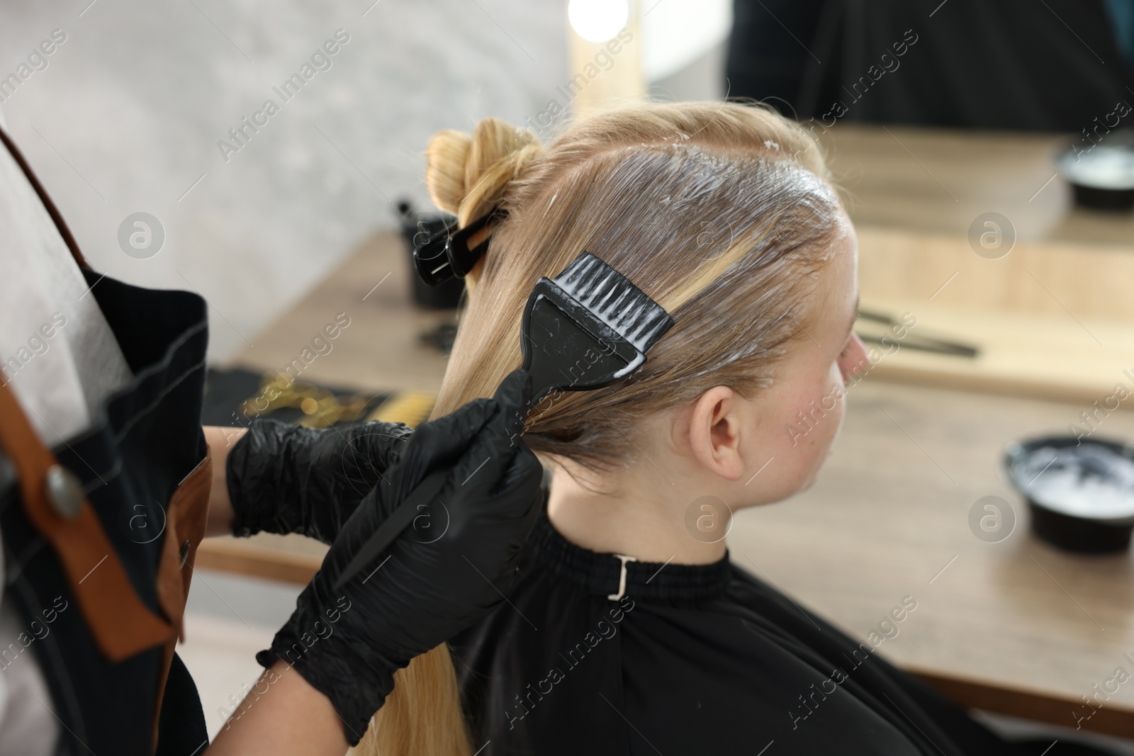 Hairdresser applying dye on woman's hair in salon, closeup Photo of Hairdresser applying dye on woman's hair in salon, closeup