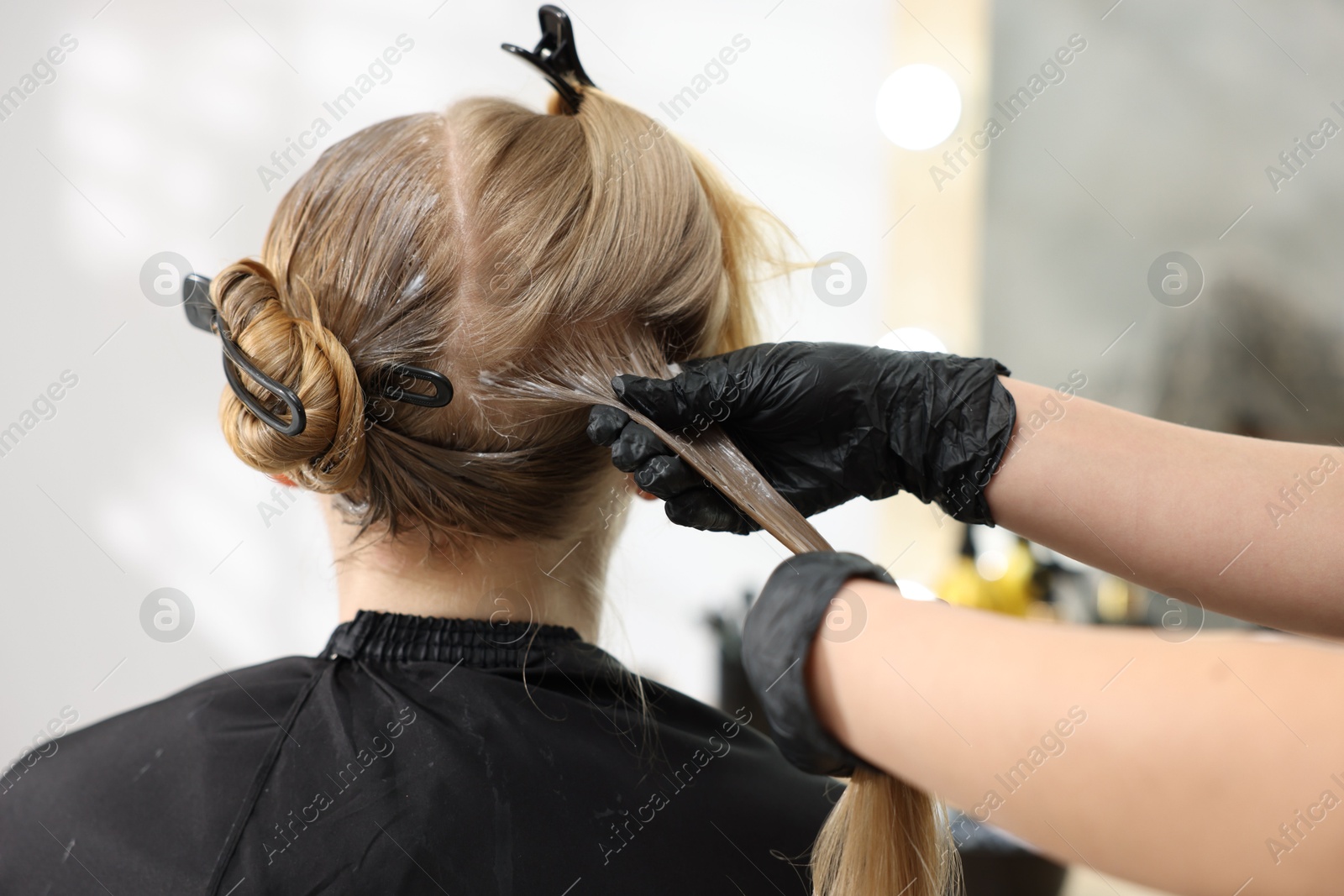 Hairdresser applying dye on woman's hair in salon, closeup Photo of Hairdresser applying dye on woman's hair in salon, closeup