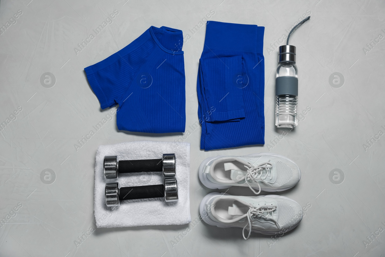 Sportswear, sneakers, dumbbells, towel and water bottle on gray textured background, flat lay Photo of Sportswear, sneakers, dumbbells, towel and water bottle on gray textured background, flat lay