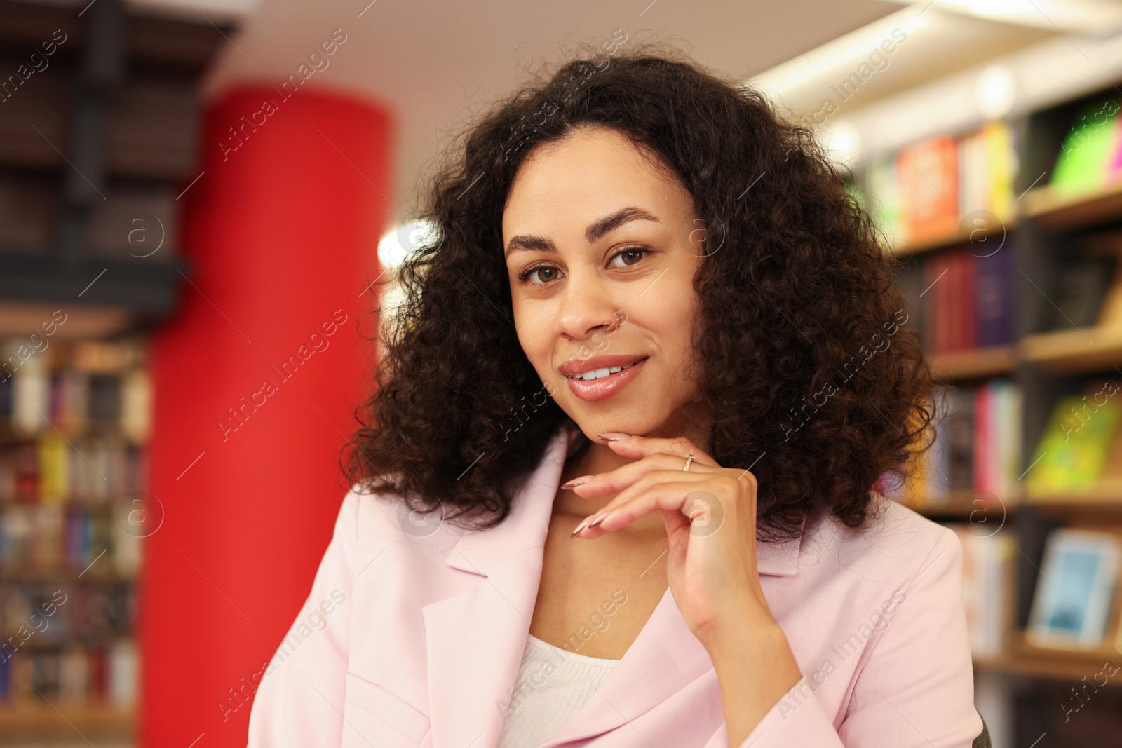 Portrait of smiling Latin American woman in bookshop Photo of Portrait of smiling Latin American woman in bookshop