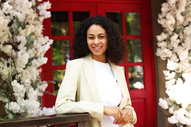 Photo of Portrait of smiling Latin American woman near building outdoors