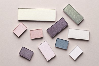 Photo of Beautiful eyeshadow refill pans on beige background, flat lay