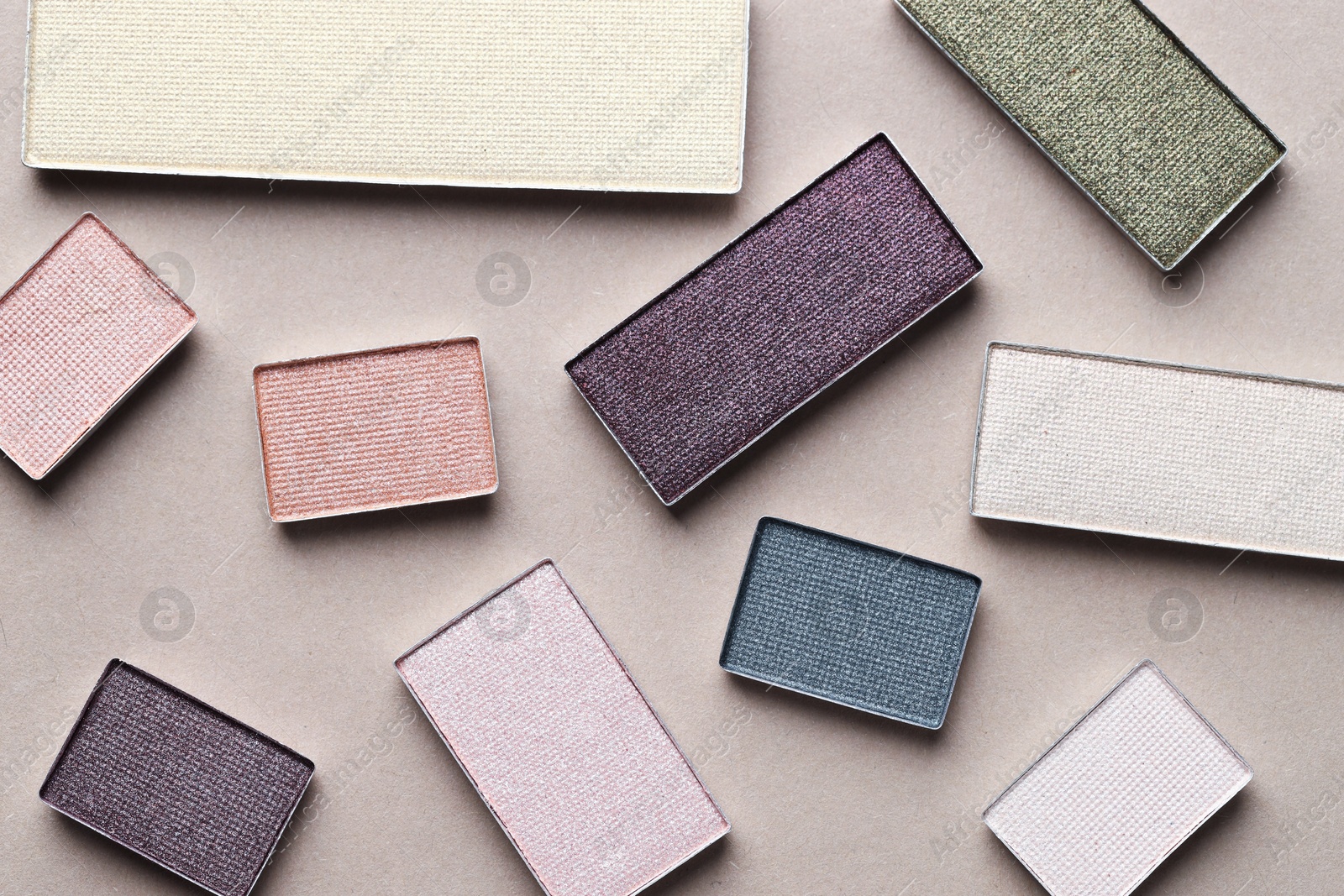 Beautiful eyeshadow refill pans on beige background, flat lay Photo of Beautiful eyeshadow refill pans on beige background, flat lay