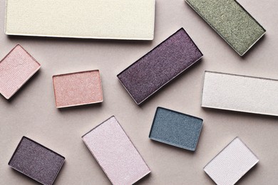 Photo of Beautiful eyeshadow refill pans on beige background, flat lay