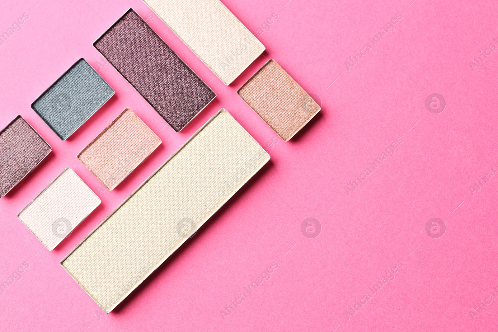 Beautiful eyeshadow refill pans on pink background, flat lay. Space for text Photo of Beautiful eyeshadow refill pans on pink background, flat lay. Space for text