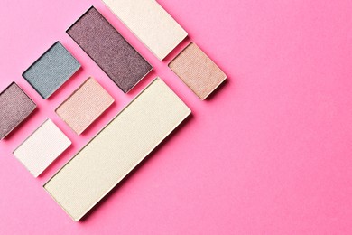 Photo of Beautiful eyeshadow refill pans on pink background, flat lay. Space for text