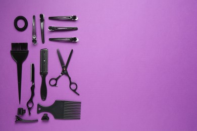 Photo of Different hairdresser's tools on violet background, flat lay. Space for text
