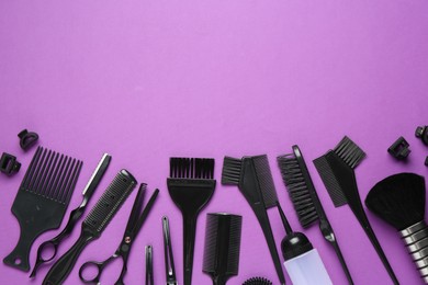 Photo of Different hairdresser's tools on violet background, flat lay. Space for text
