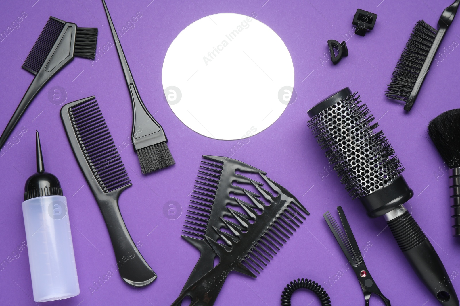Photo of Different hairdresser's tools on purple background, flat lay