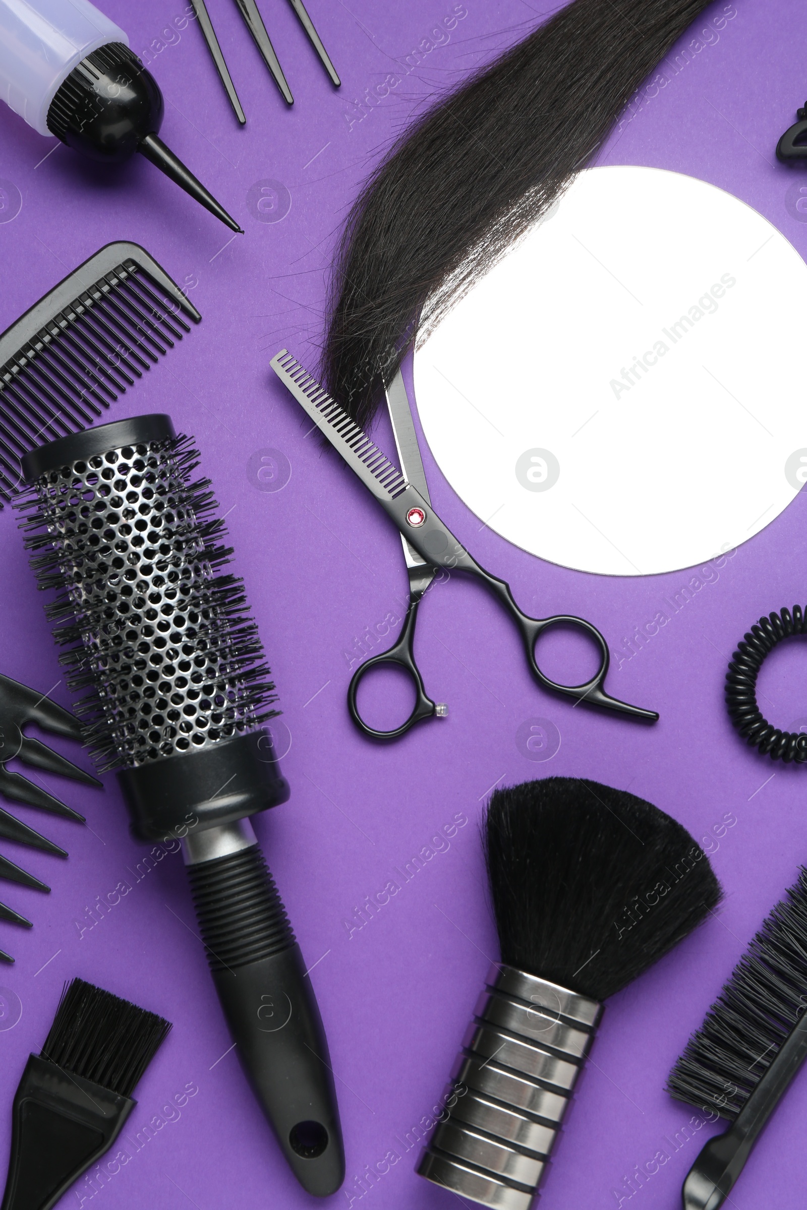 Photo of Different hairdresser's tools on purple background, flat lay