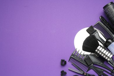 Photo of Different hairdresser's tools on purple background, flat lay. Space for text