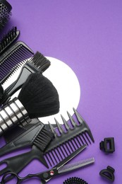 Photo of Different hairdresser's tools on purple background, flat lay