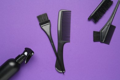 Photo of Different hairdresser's tools on purple background, flat lay