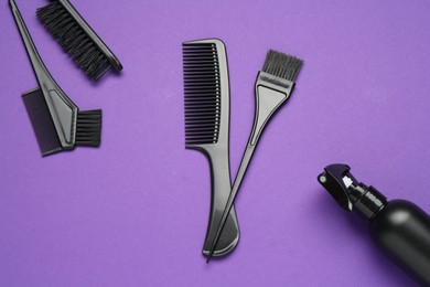Photo of Different hairdresser's tools on purple background, flat lay