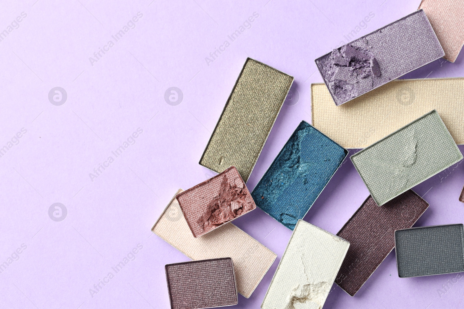 Beautiful eyeshadow refill pans on lilac background, flat lay. Space for text Photo of Beautiful eyeshadow refill pans on lilac background, flat lay. Space for text