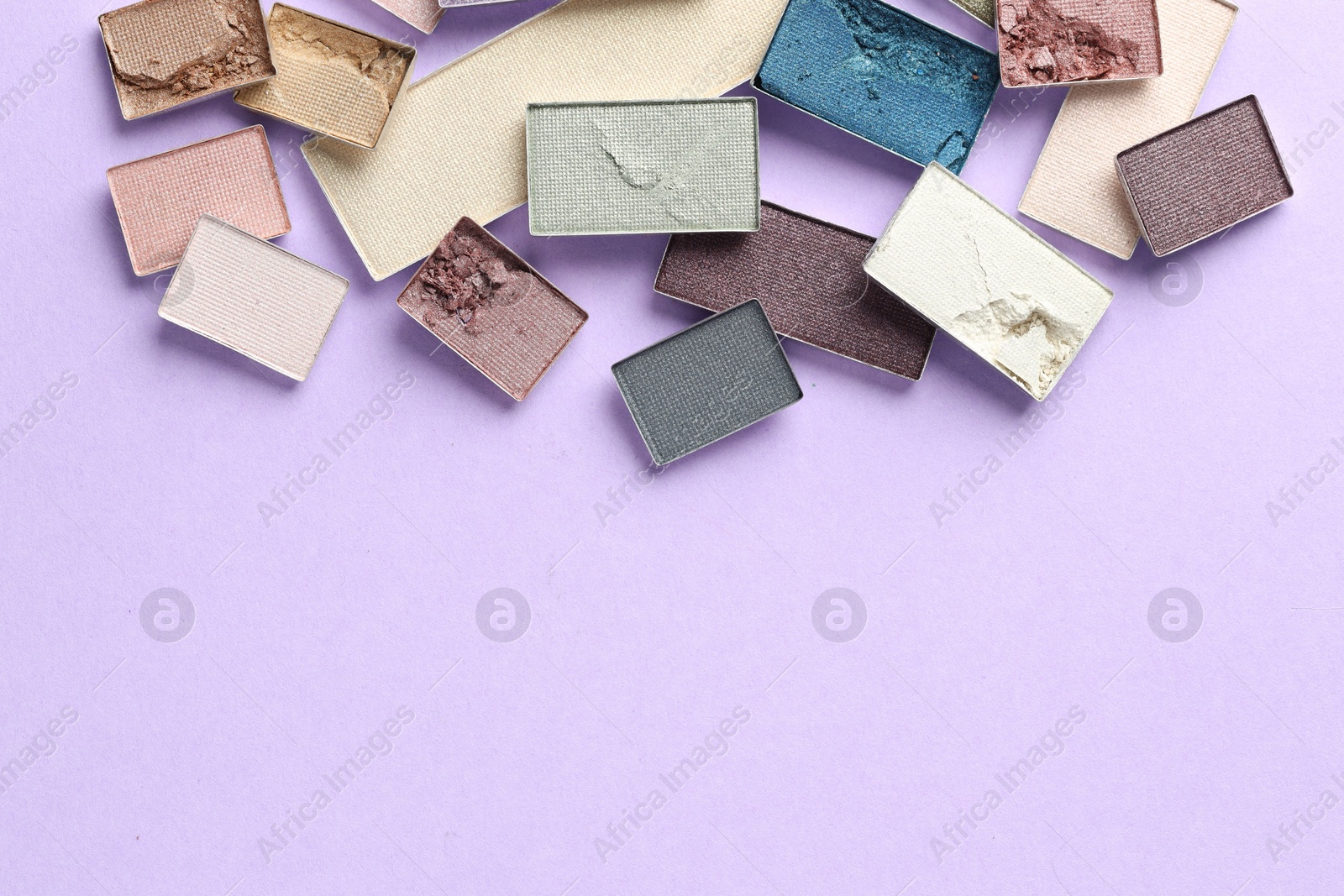 Beautiful eyeshadow refill pans on lilac background, flat lay. Space for text Photo of Beautiful eyeshadow refill pans on lilac background, flat lay. Space for text