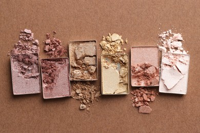 Photo of Beautiful eyeshadow refill pans on brown background, flat lay