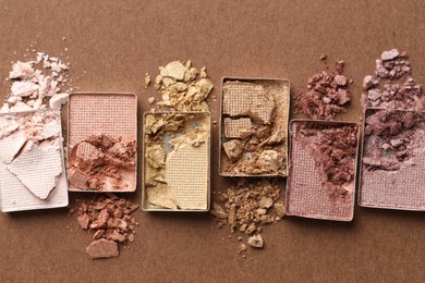 Photo of Beautiful eyeshadow refill pans on brown background, flat lay