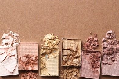 Photo of Beautiful eyeshadow refill pans on brown background, flat lay. Space for text
