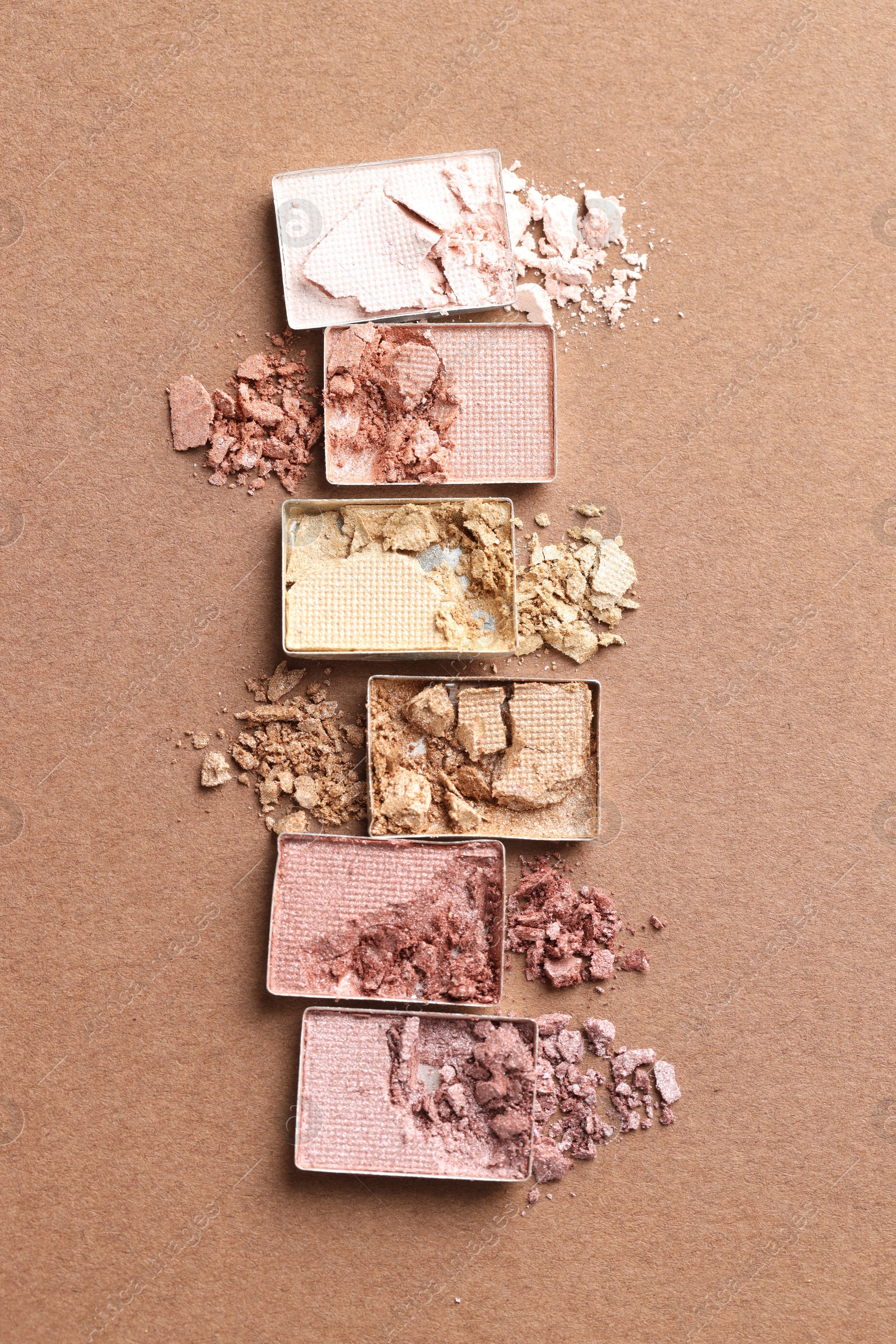 Beautiful eyeshadow refill pans on brown background, flat lay Photo of Beautiful eyeshadow refill pans on brown background, flat lay