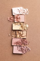 Photo of Beautiful eyeshadow refill pans on brown background, flat lay