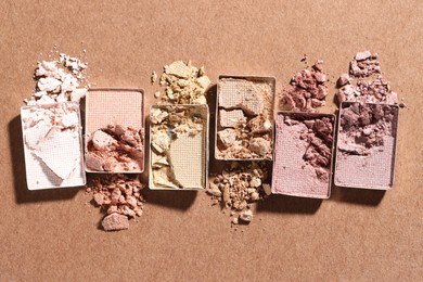 Photo of Beautiful eyeshadow refill pans on brown background, flat lay